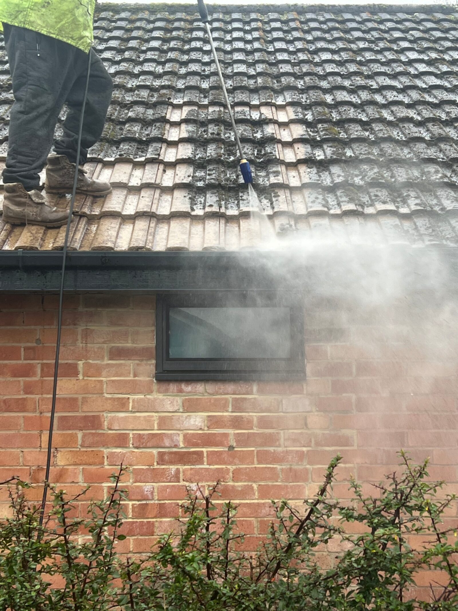 Pressure washing in progress on roof